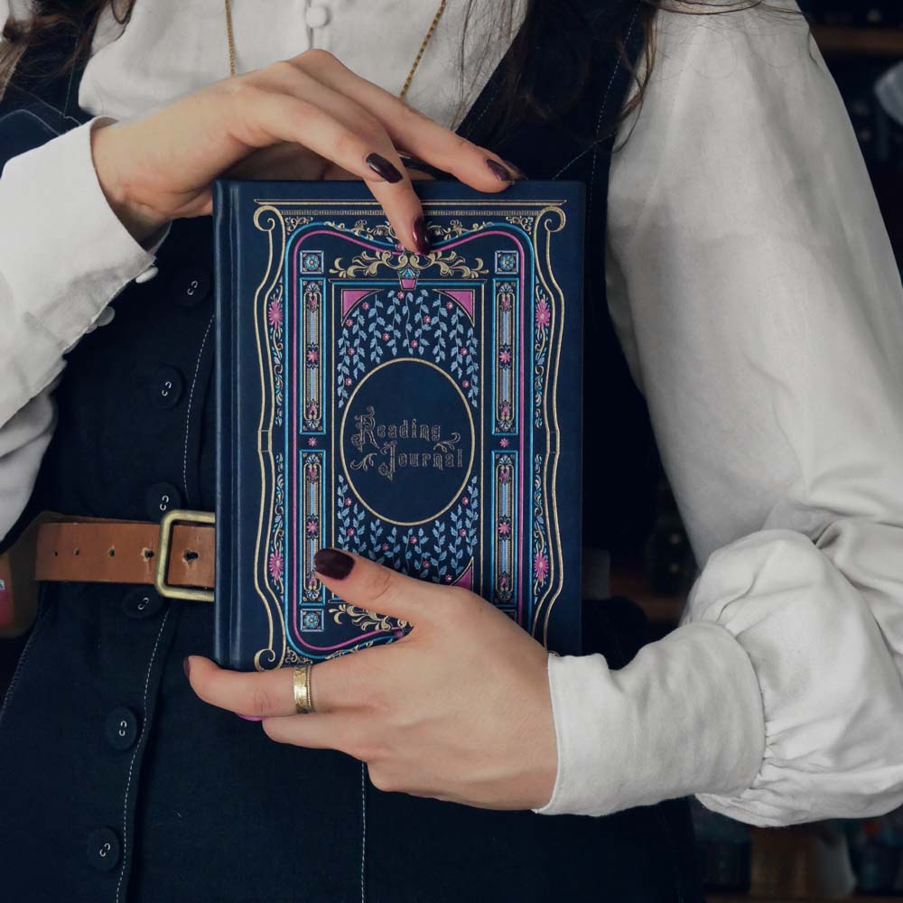 Blue faux leather reading journal with pink flowers, light blue leaves and gold foil filagree