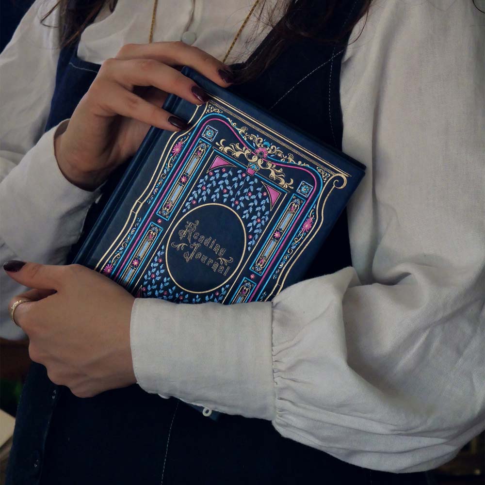 Blue faux leather reading journal with pink flowers, light blue leaves and gold foil filagree