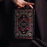 Decorative dark and moody reading journal held by a hand against a dark background