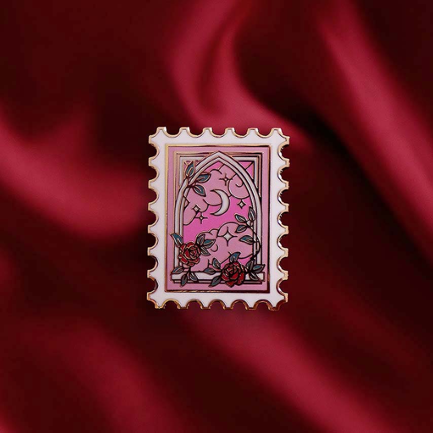 Decorative pin with a pink design on a red fabric background