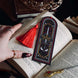 Fantasy bookmark with sword, crown and serpents design, red tassel, gothic black background