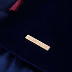 The back of the navy Serpents & Swords navy blue eReader case shows the gold logo badge and pink passel on a dark blue background.