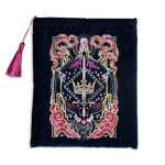 Hand holding a blue book sleeve with decorative fantasy embroidery with red background book sleeve