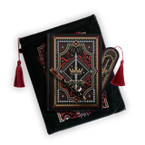 The journal bundle from the Serpents & Swords collection. This black variation includes a book sleeve, journal, pen and bookmark from the collection. All feature a design with motifs of crowns swords and snakes in shades of white, red and gold. The journal, pen and bookmark feature gold foiling while the velvet book sleeve is embroidered. The sleeve and bookmark also feature red tassels.