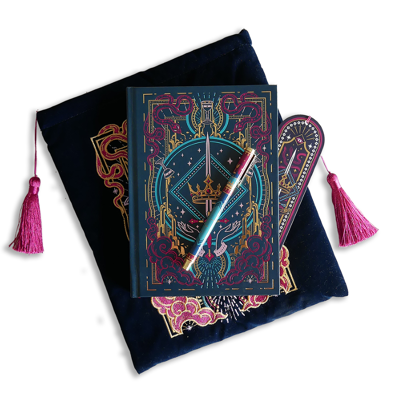 The blue Serpents & Swords bundle shows a book- sleeve, journal, pen and bookmark. Each piece features an intricate fantasy book inspired motif of a crown, sword, snakes and goblets in shades of pink, teal and gold on a deep blue background. The sleeve and bookmark also have bright pink tassles.