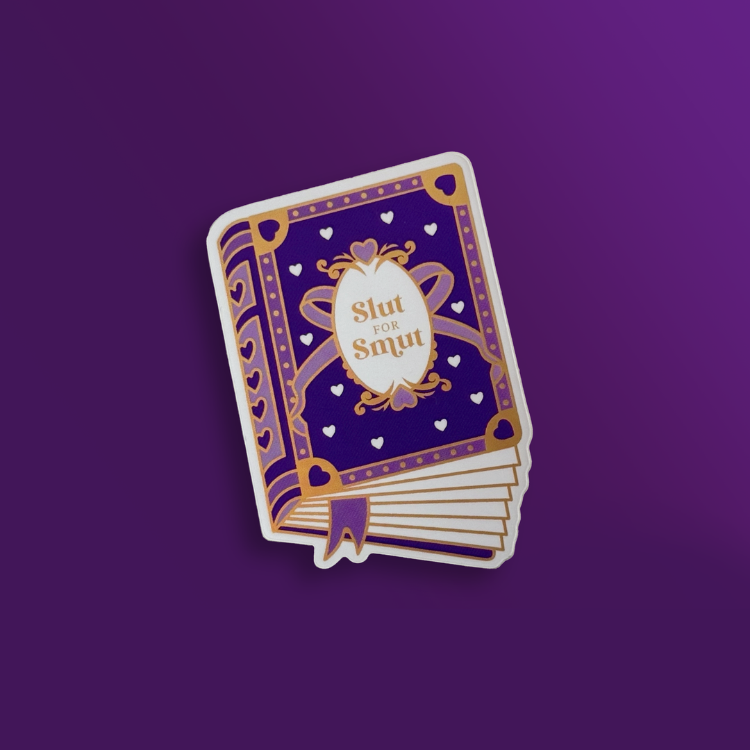 sticker on a purple background. Sticker is in the shape of a book that has a purple cover with purple and white hearts, a bow and gold accents