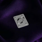 A The Quirky Cup Collective charm anchor on a dark purple fabric background. The silver rectangle shaped clip is used to attach Charmlets to flat surfaces (such as your device).