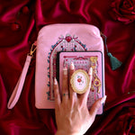 Sugar & Spice eReader decor bundle shows a light pink eReader case and sticker insert (both with red, white and green detailing) alongside a matching Clingie (similar to a pop socket!) and charmlet. The sweet romance kindle decor set sits on a red fabric background.
