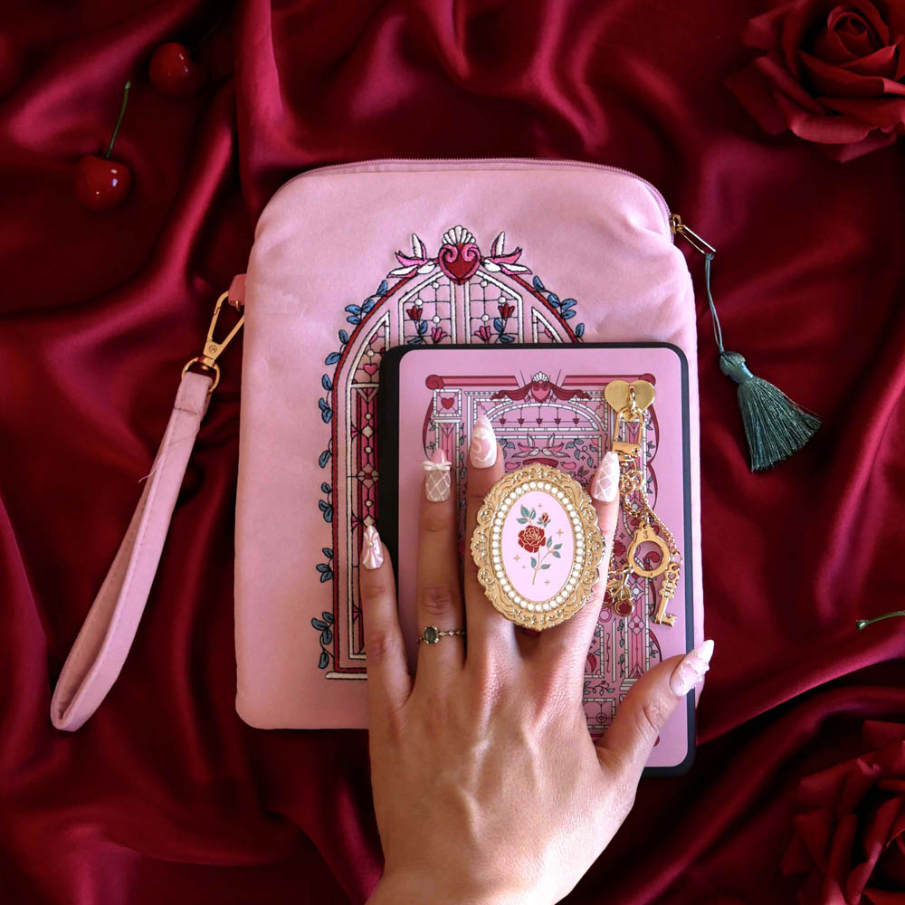 Sugar & Spice eReader decor bundle shows a light pink eReader case and sticker insert (both with red, white and green detailing) alongside a matching Clingie (similar to a pop socket!) and charmlet. The sweet romance kindle decor set sits on a red fabric background.
