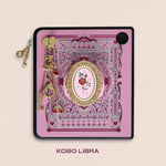 Decorated Kobo Libra with a set of aesthetic ereader accessories. Theme is spicy romance and includes sroses, eggplants, handcuffs, hearts, swallows and feathers. Colours are pink, red, teal, white and gold. 