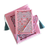 The Sugar & Spice journal bundle includes a Reading Journal, bookmark, pen and book sleeve. All items are a light pink colour and feature intricate red, light pastel green and white detailing of romantic floral imagery. The Book sleeve features detailed embroidery and both the sleeve and bookmark feature a light mint green tassle.