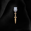 A dust plug design by The Quirky Cup Collective sits on a black fabric background. The gold sword design (as part of the romantasy e-reader decor release) shows a small gold dagger with black detailing.