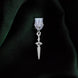 A dust plug design by The Quirky Cup Collective sits on a green fabric background. The silver sword design (as part of the romantasy e-reader decor release) shows a small gold dagger with black detailing.