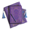 The wisteria reading journal bundle from the classic book inspired Literati collection. This soft lilac variation includes a book sleeve, reading journal, pen and bookmark from the collection. All share a slightly Victorian book inspired motif in shades of gold, pink, purple and blue. The foiled reading journal, pen and bookmark feature intricate gold foiling while the velvet book sleeve is embroidered. The sleeve and bookmark also feature light blue tassels.