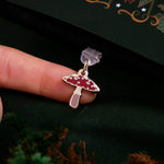 toadstool mushroom charm attached to a USB-C plastic dust plug to protect your charging port. Accessory sits against a green background