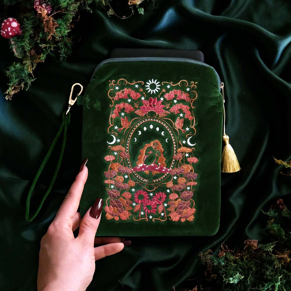 Hand holds a Green velvet Kindle and Kobo sleeve with embroidered botanical fall autumn inspired design, padded eReader protective case with zip closure and back pocket