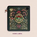 Decorated Kobo Libra with a set of aesthetic ereader accessories. Theme is cottage core and includes a toadstool mushroom, lily of the valley, nasturtium, butterflies, dandelions, moons and stars. Colours are green, red, white and gold. 