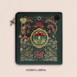 Decorated Kobo Libra with a set of aesthetic ereader accessories. Theme is cottage core and includes a toadstool mushroom, lily of the valley, nasturtium, butterflies, dandelions, moons and stars. Colours are green, red, white and gold. 