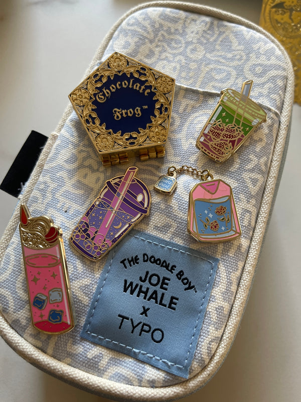 A collection of Quirky enamel pin designs on a pencil case,